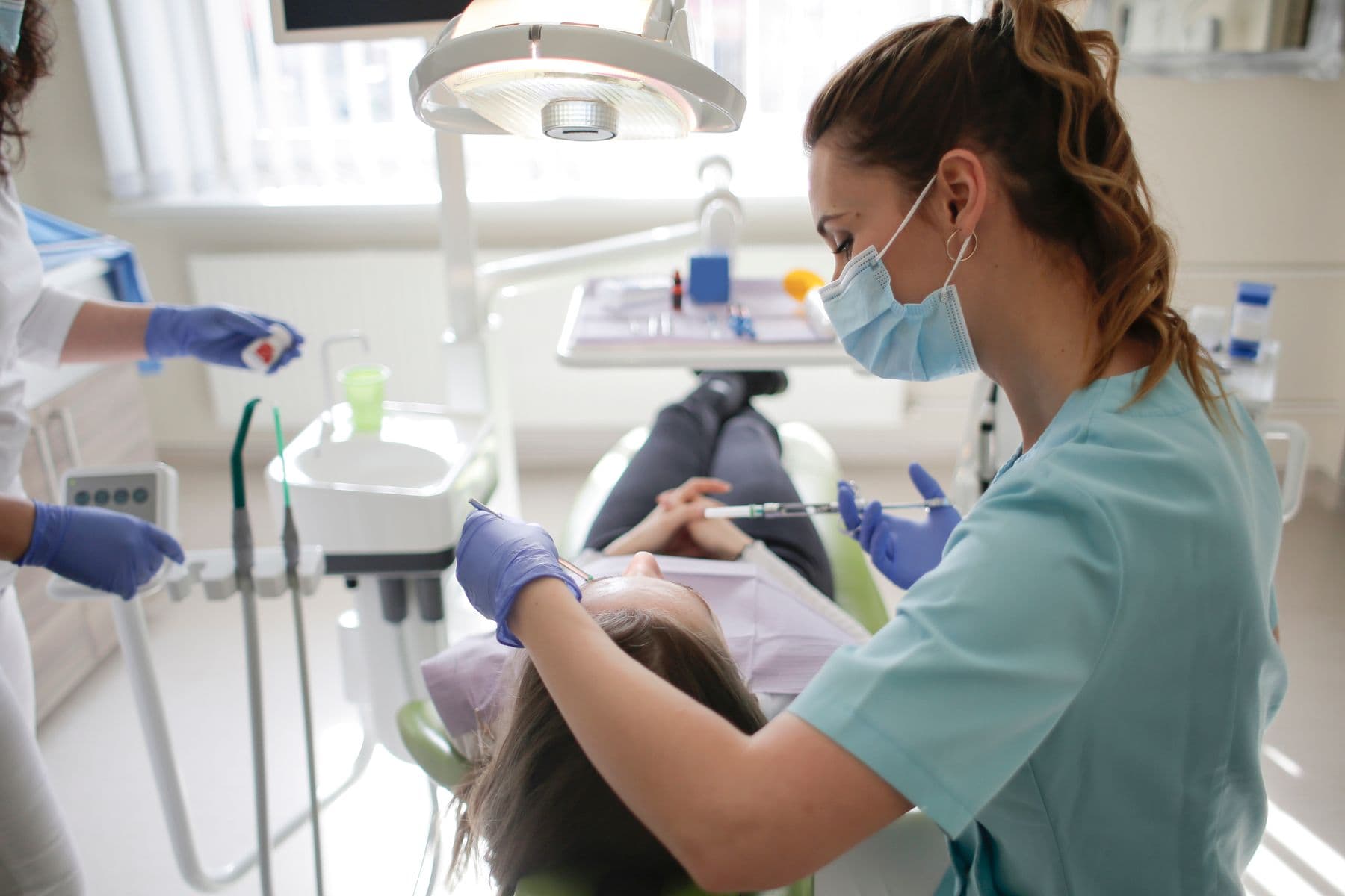 A dental professional treating a patient in a modern clinic