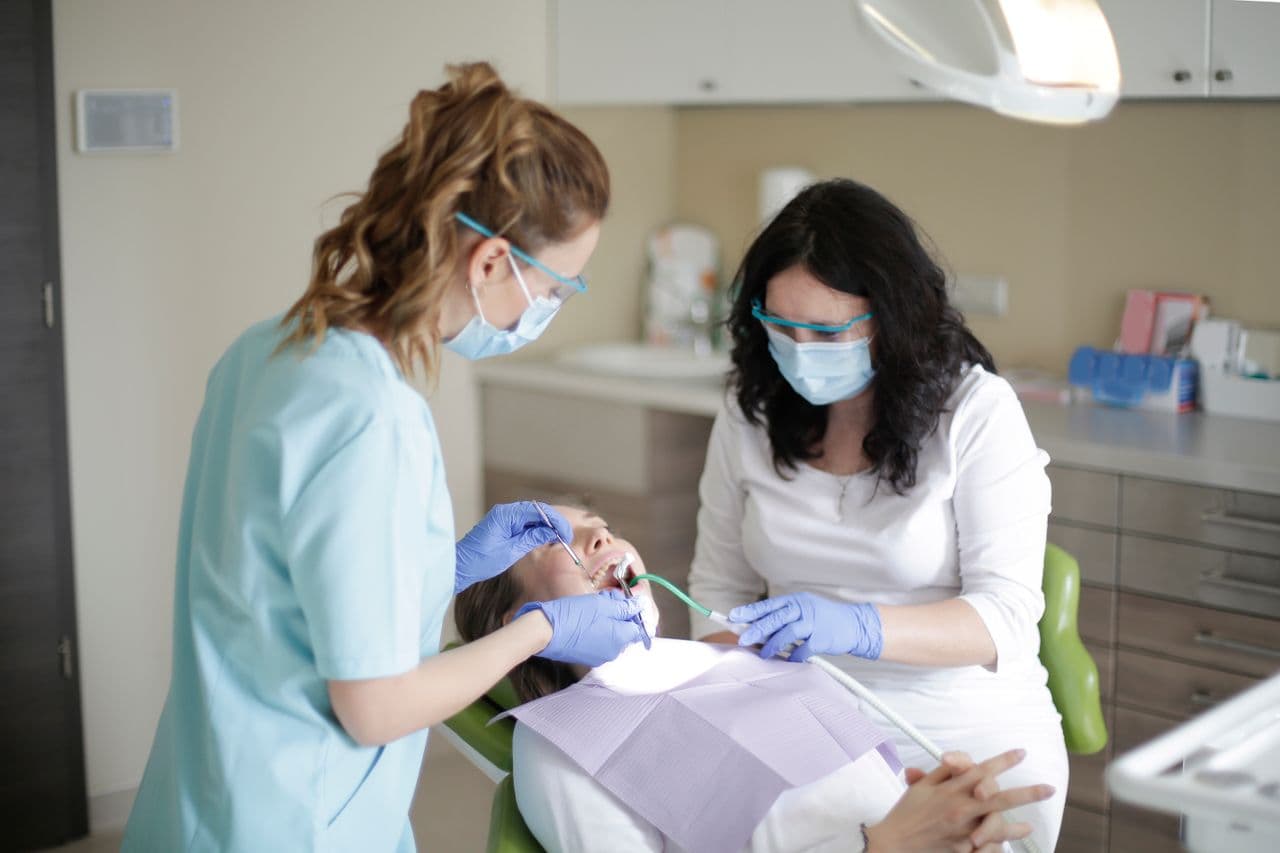 Tandläkare och tandhygienist som behandlar en patient på en klinik