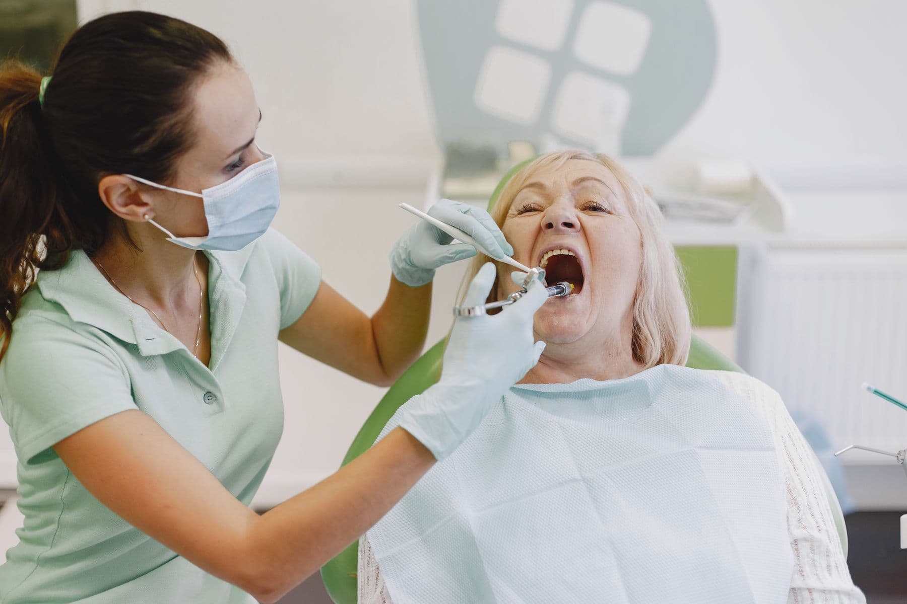 Tandhygienist som behandlar en äldre patient